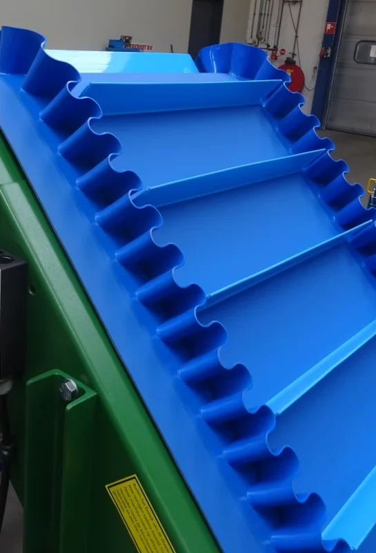 Close-up van een blauwe PU-opvoerband met meenemers en golfranden