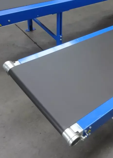 Close-up van een vlakke zwarte PVC-transportband op blauw frame