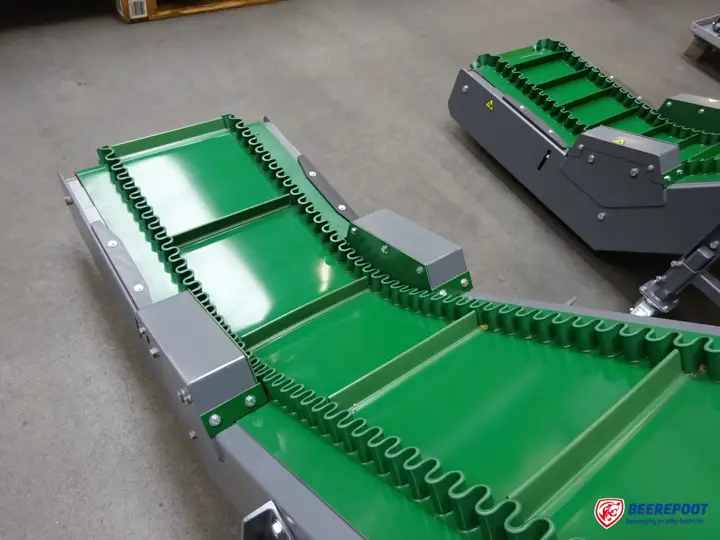 Groene PVC-opvoerband met meenemers en golfranden