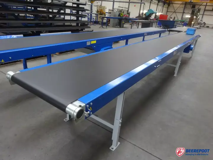 Vlakke zwarte PVC-transportband op blauw frame