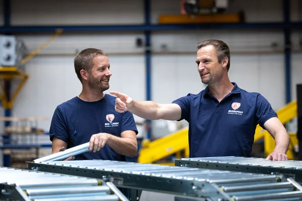 Jordi met een collega, samen aan het werk met rollenbanen